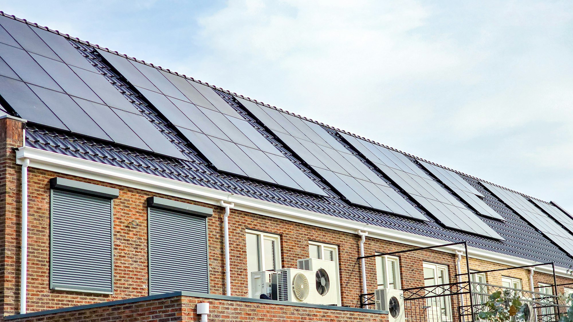 air source heat pump unit installed outdoors at a modern home with solar panels in the Netherlands